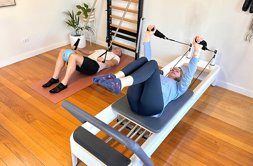 A duo Pilates class with clients working on their individual programs