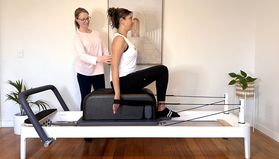 Vanessa is guding a client in a postural exercise on the Reformer