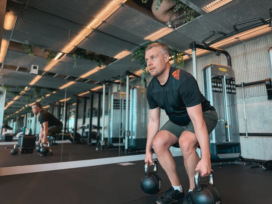 Athlete performing deadlifts with kettlebells
