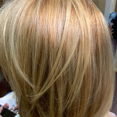 Layered blonde haircut with soft feathered texture – Per Lei Salon