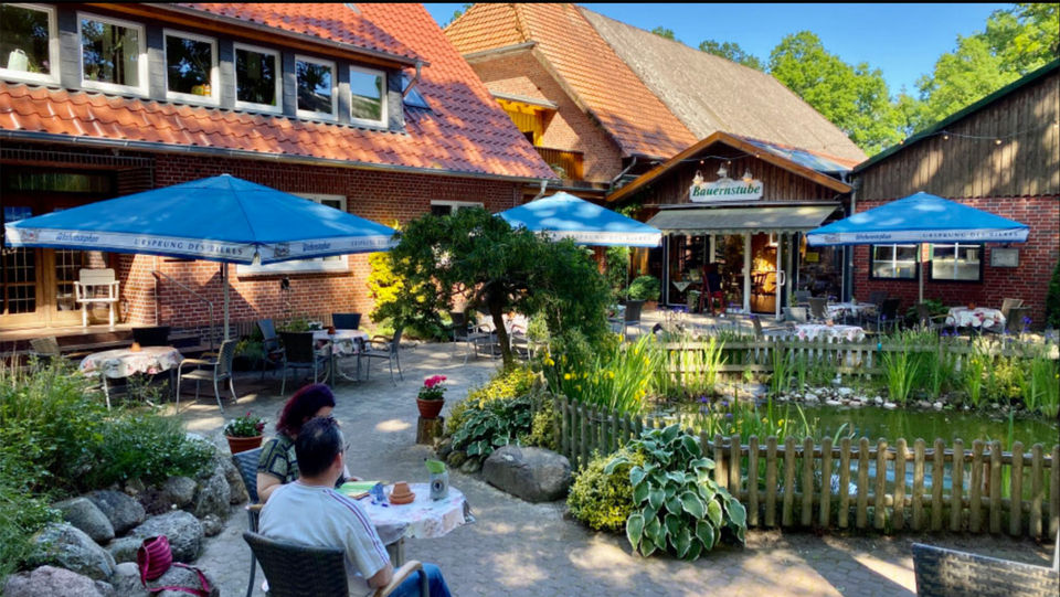 Gäste im gemütlichen Biergarten mit umzäuntem Teich bei Meyerhöms Bauernstube