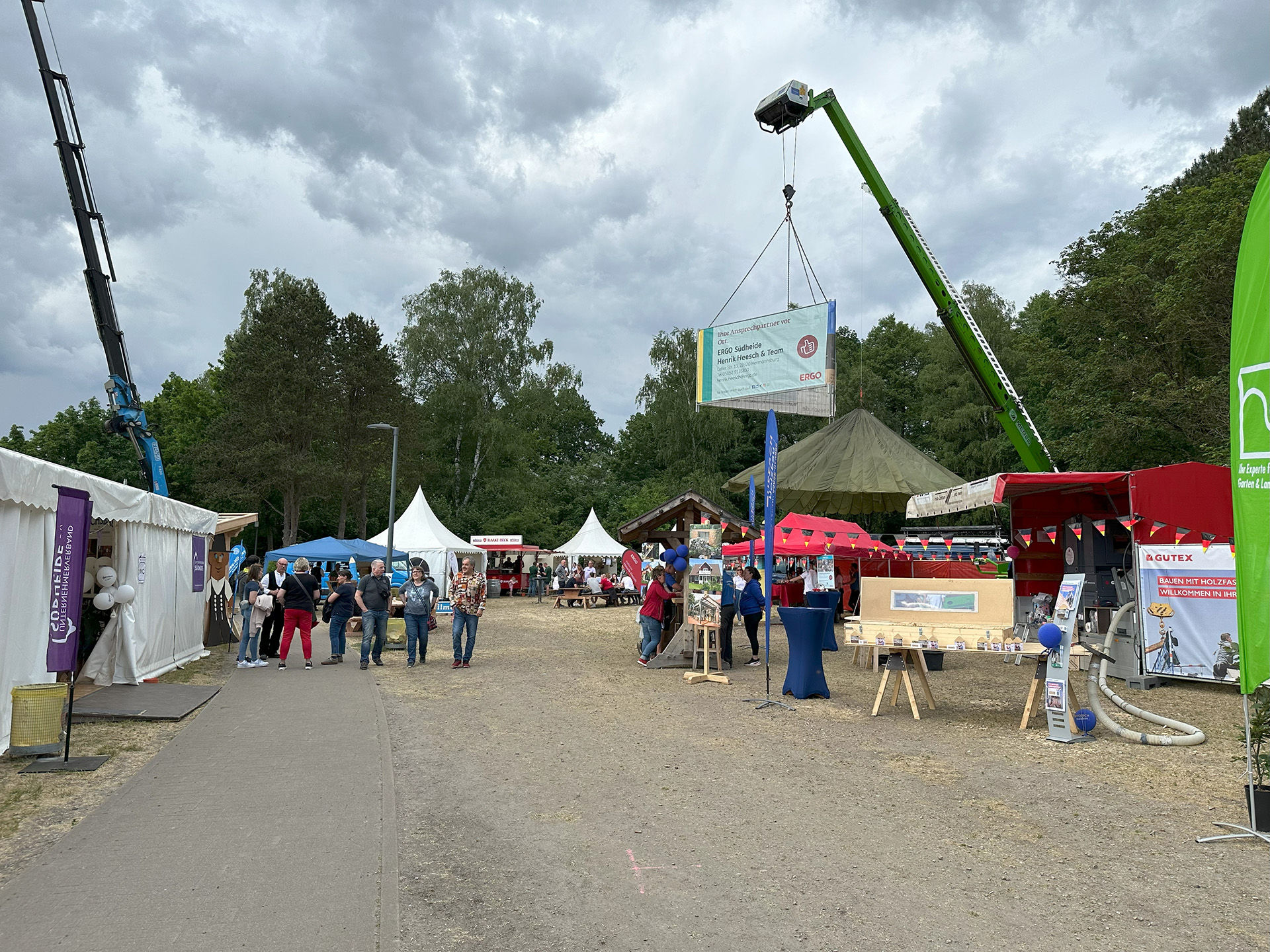 Eine gut besuchte Gewerbeschau mit Ausstellungsständen, Zelten und Kränen