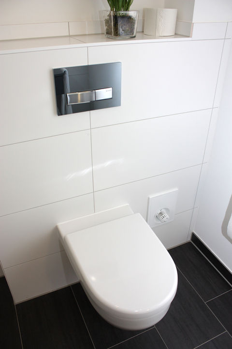 Minimalistisches Badezimmer mit wandhängendem WC und schwarzem Boden