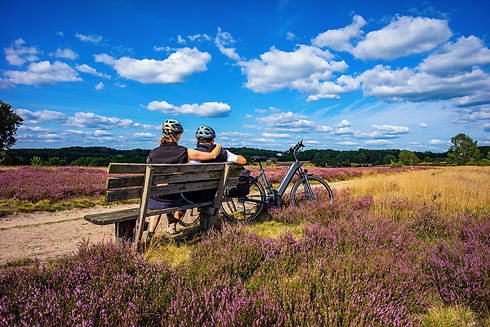 Radfahrer sitzen auf einer Bank in der Lüneburger Heide