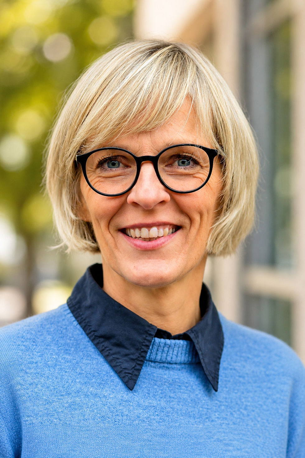 Lächelnde Frau mit Brille und blonden Haaren
