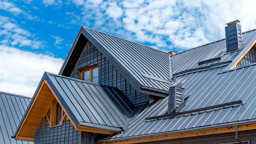 Bild: Haus mit komplexem Stehfalz-Metalldach, Holzdetails und Fenstern
