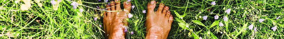 Pies descalzos en contacto con la tierra, símbolo de enraizamiento y conexión corporal en una sesión de bioenergética