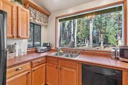 kitchen with fridge, dishwasher, sink, and large windows