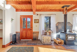 wooden front door with fireplace off to the side