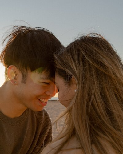 Couple smiling and touching foreheads at sunset