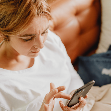 a woman looking at her phone, presumably symptom tracking because of her GI dietitian's recommendations