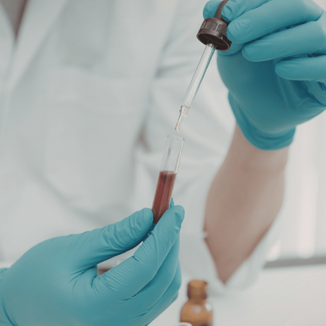 an image of a lab tech performing functional lab testing with a vial and dropper