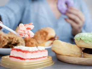 an image of a woman eating multiple meals and desserts, exhibiting binge eating disorder
