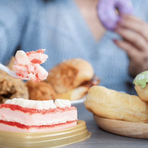 an image of a woman eating multiple meals and desserts, exhibiting binge eating disorder