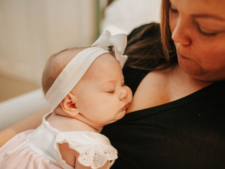A baby sleeping on her mother's chest.