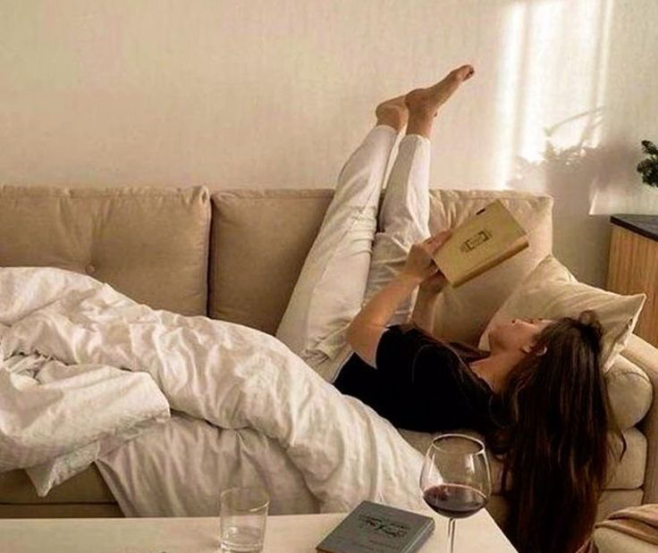 woman lying on the couch reading
