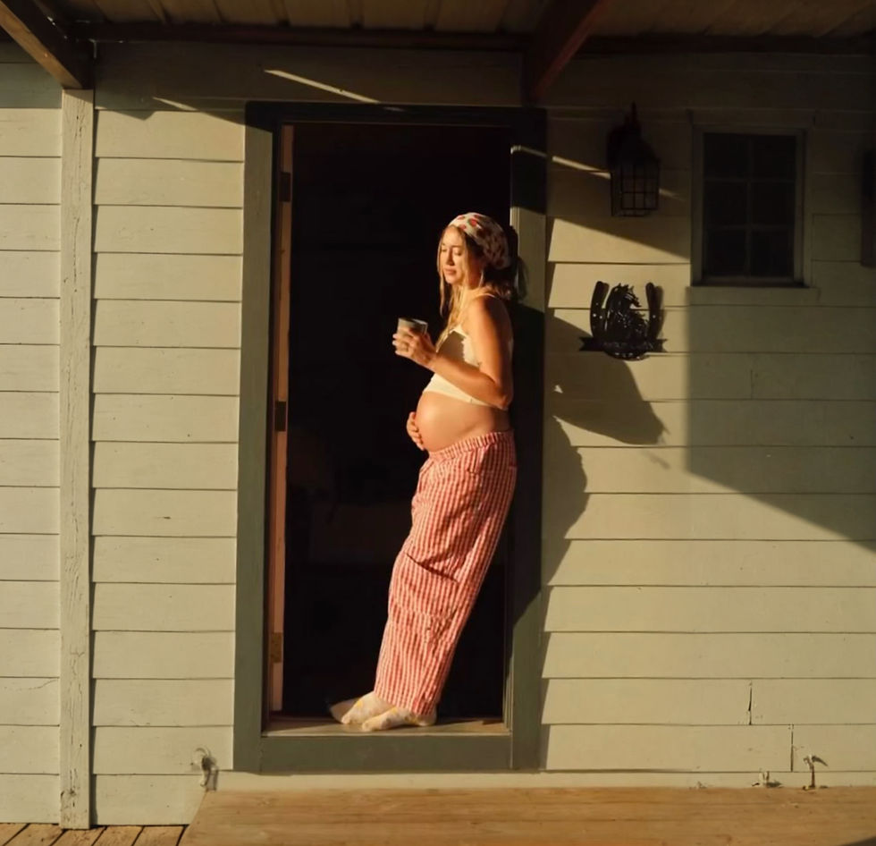 pregnant woman standing in doorway holding belly