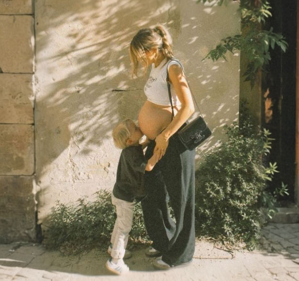film photo little kid kissing moms pregnant belly