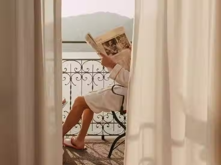 man in a robe reading the newspaper at a luxury hotel