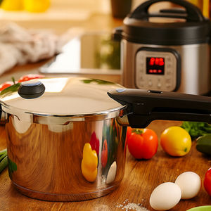 Ein Schnellkochtopf ohne Schadstoffe aus Edelstahl steht auf einer Küchenarbeitsplatte, dahinter ein Multikocher – beide umgeben von frischen Zutaten wie Eiern und Gemüse. Ideal für gesundes, nachhaltiges Kochen im Alltag.