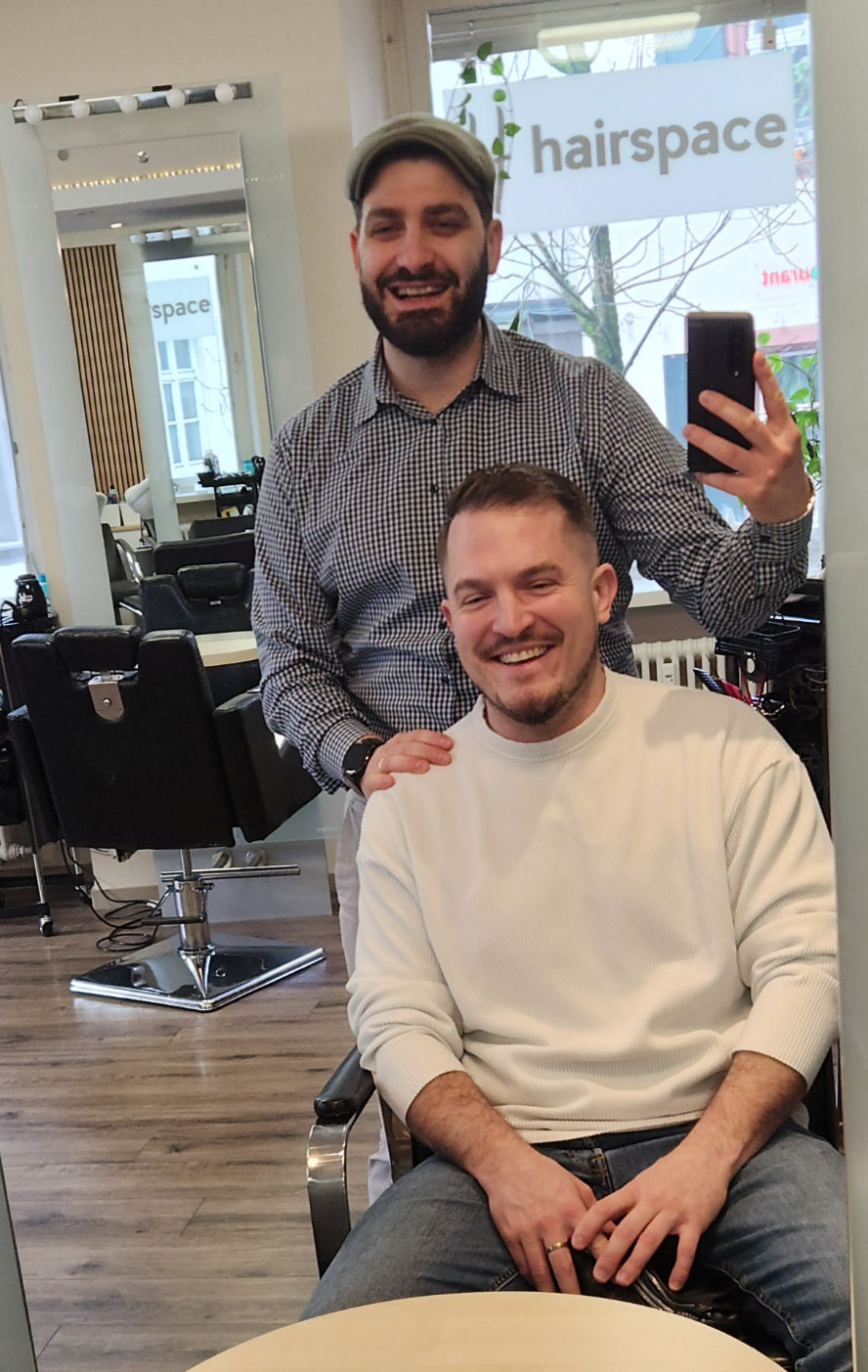 Barber und zufriedener Kunde lächeln