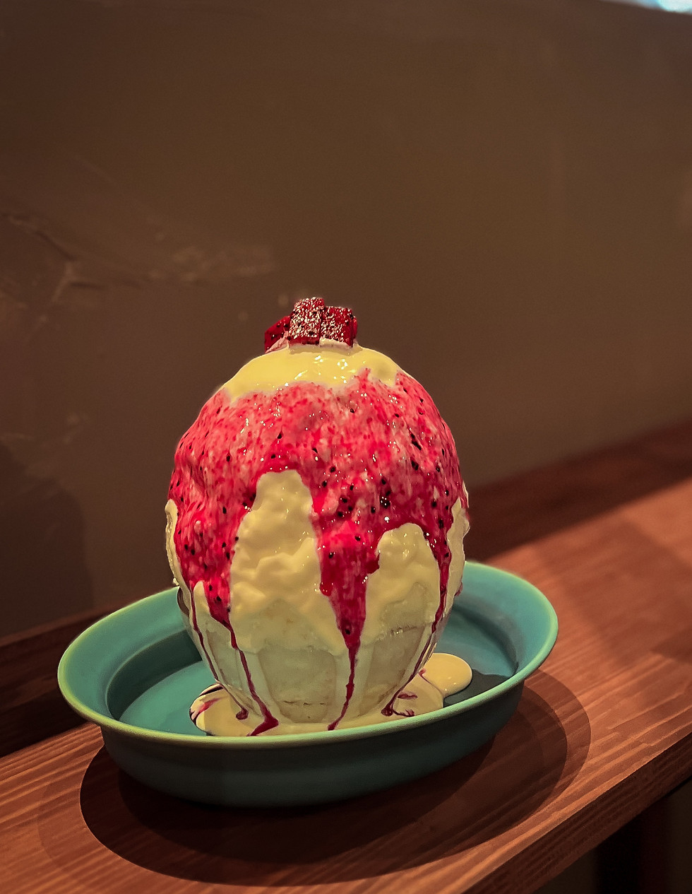 Naha shaved ice with red syrup on a wooden counter