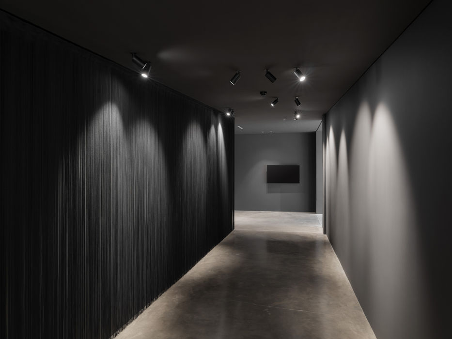 Dark corridor in Lübbering GmbH — black walls with linear lighting elements and architectural accents
