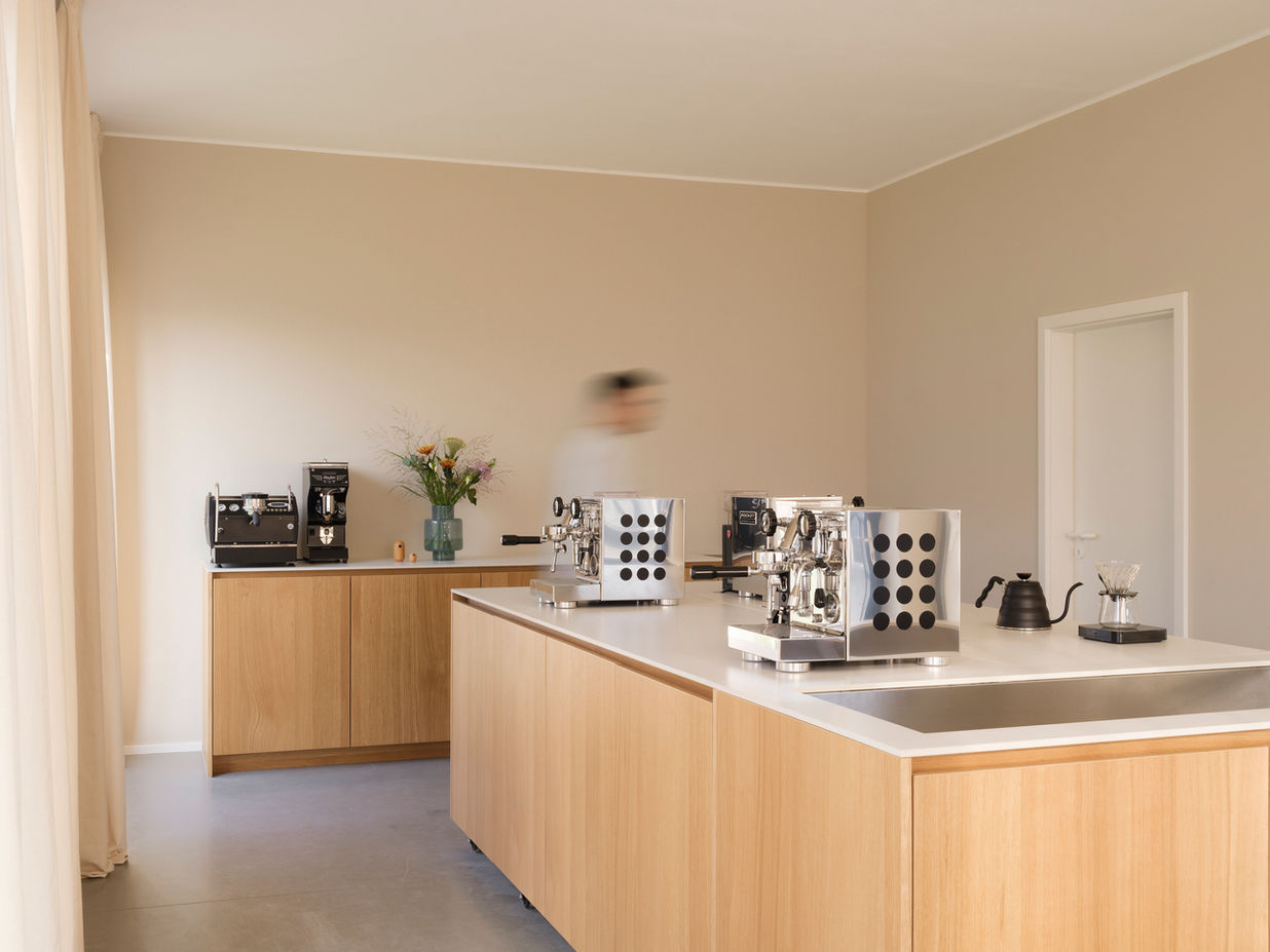 Coffee preparation in Cafeschule Holm, Potsdam — blurred movement of person working at espresso station