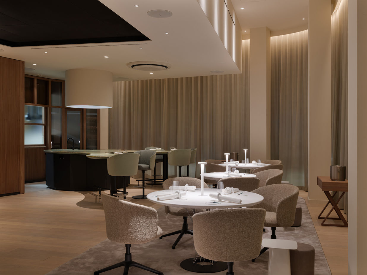 Rear bar area in La Vie Dusseldorf — green sculptural counter with view into kitchen space