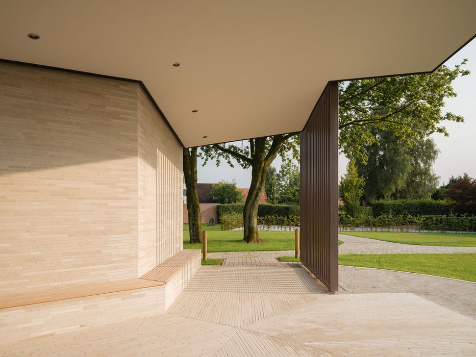 Interior view of cemetery pavilion Welt Wärelte — floating steel structure, brick seating wall and central tree opening