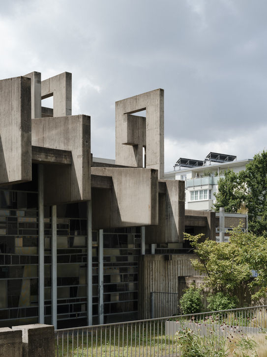 Rear perspective of church facade — monumental concrete structure with sculptural geometry