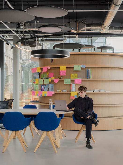 Interior scene in Formo offices — person working at table with shelving and office materials in background