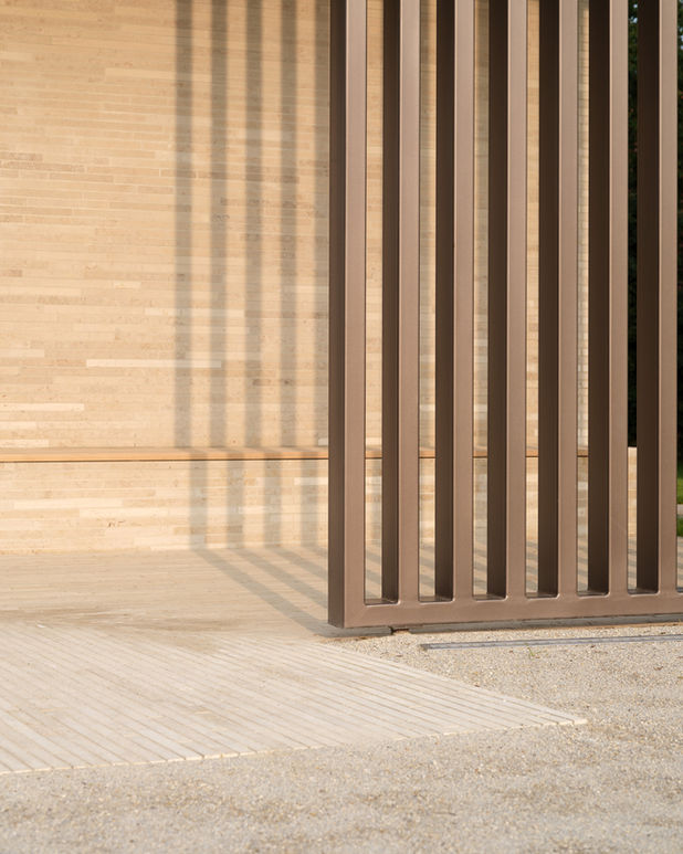 Close-up of pavilion structure — suspended steel beams with soft depth of field and blurred background