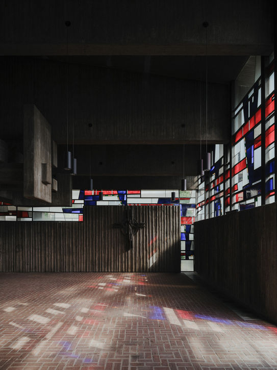 Church interior in Cologne — central crucifix framed by brutalist concrete architecture