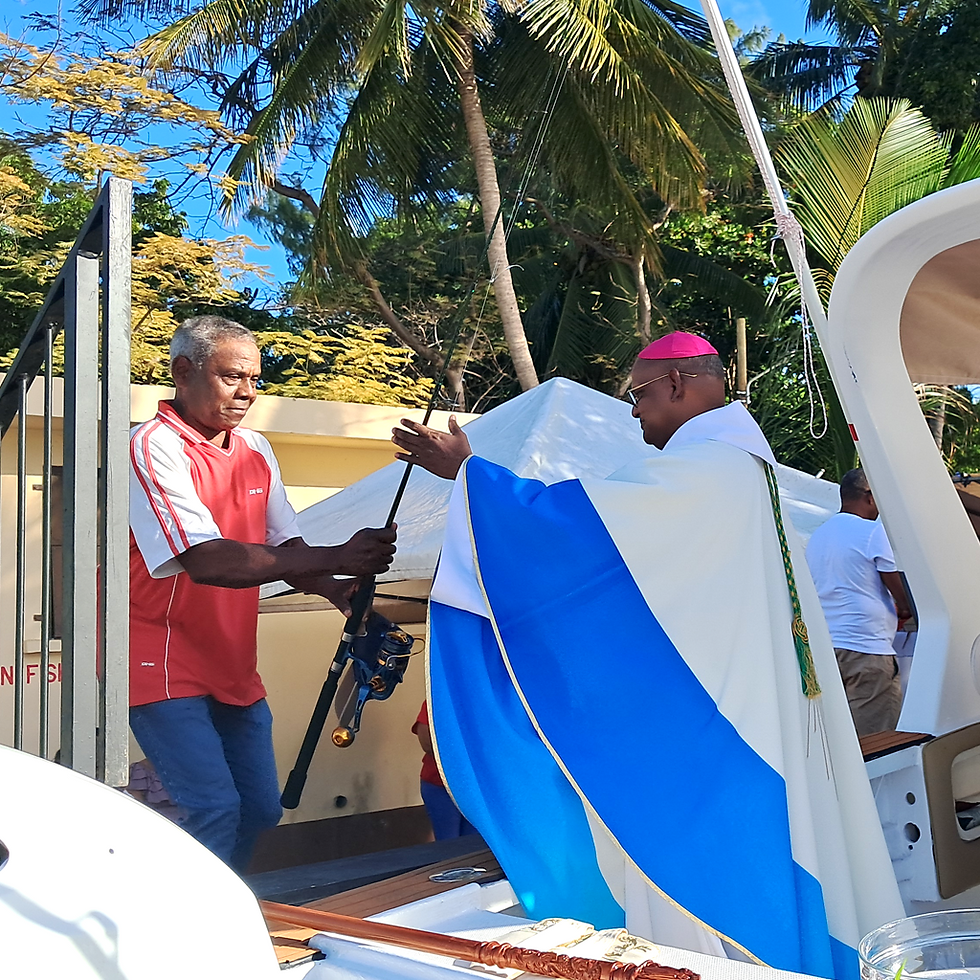 Mgr Durhône recevant symboliquement des outils de pêche lors de l’offertoire