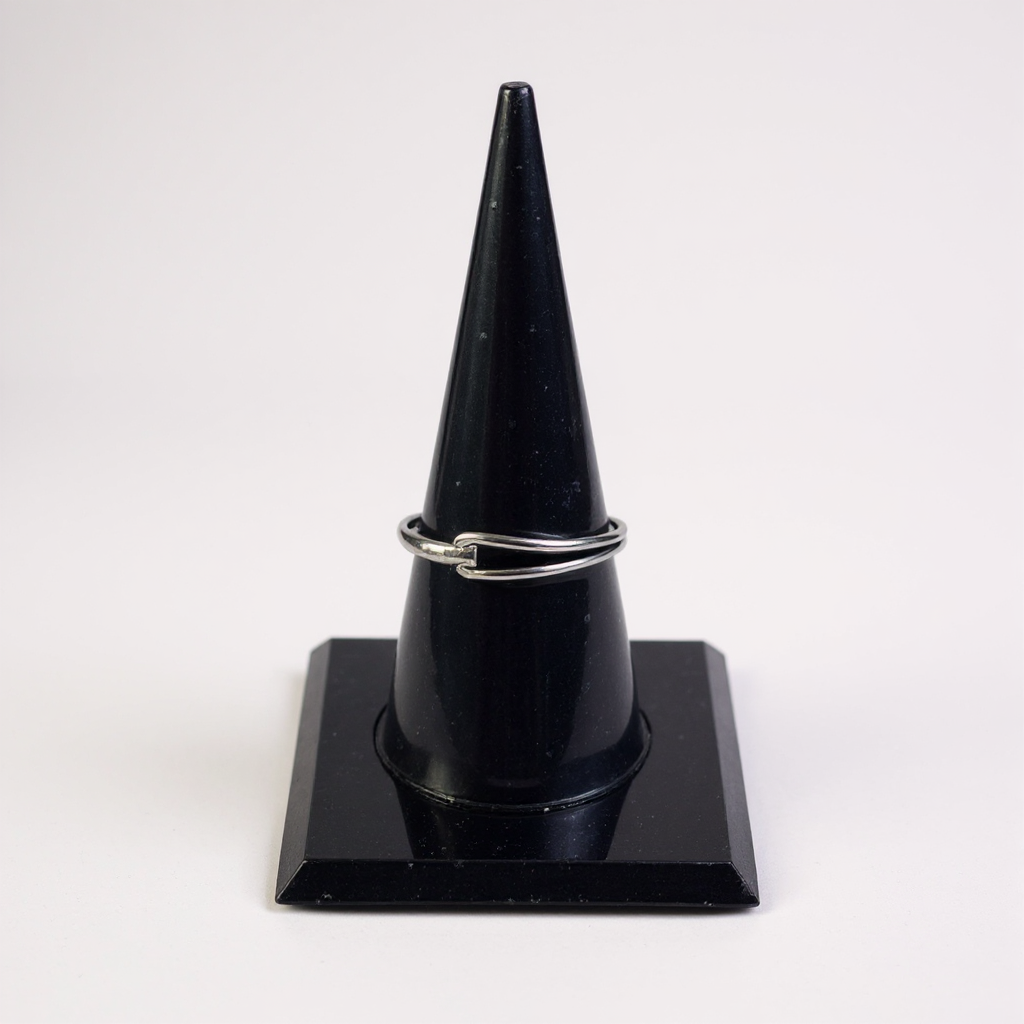 Silver open-ended ring on a sleek black display stand.