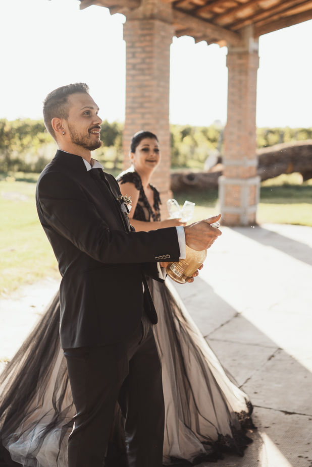Jonathan apre una bottiglia mentre Cinzia festeggia durante il ricevimento di nozze
