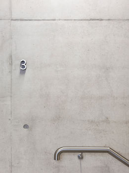 Photograph of floor numbers, cut from 20mm thick white acrylic with black spray painted edges.