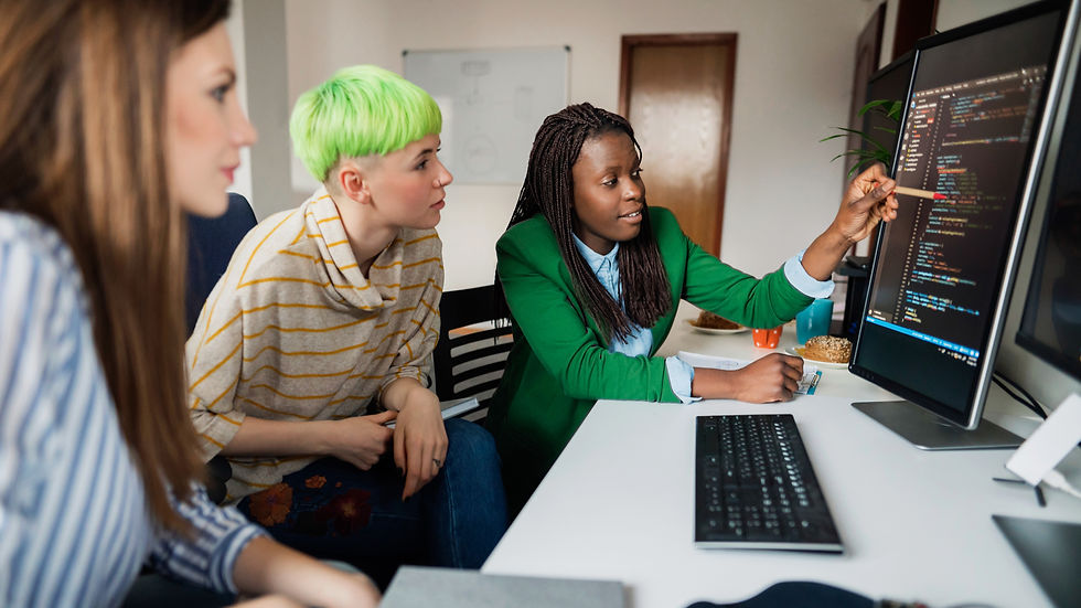 Three software developers in an office, working on a low-code platform.