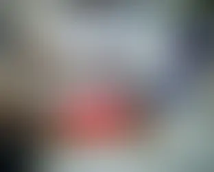 Mão usando um mouse de computador ao lado de um laptop aberto mostrando gráficos, com uma sobreposição vermelha indicando dor no pulso.