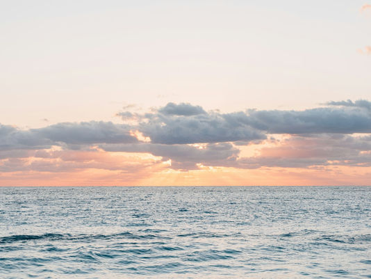 Peaceful sunset over calm water, representing balance during perimenopause and menopause