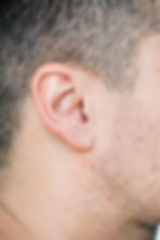 Detailed image highlighting human ear structure, natural texture, and surrounding facial hair stubble.