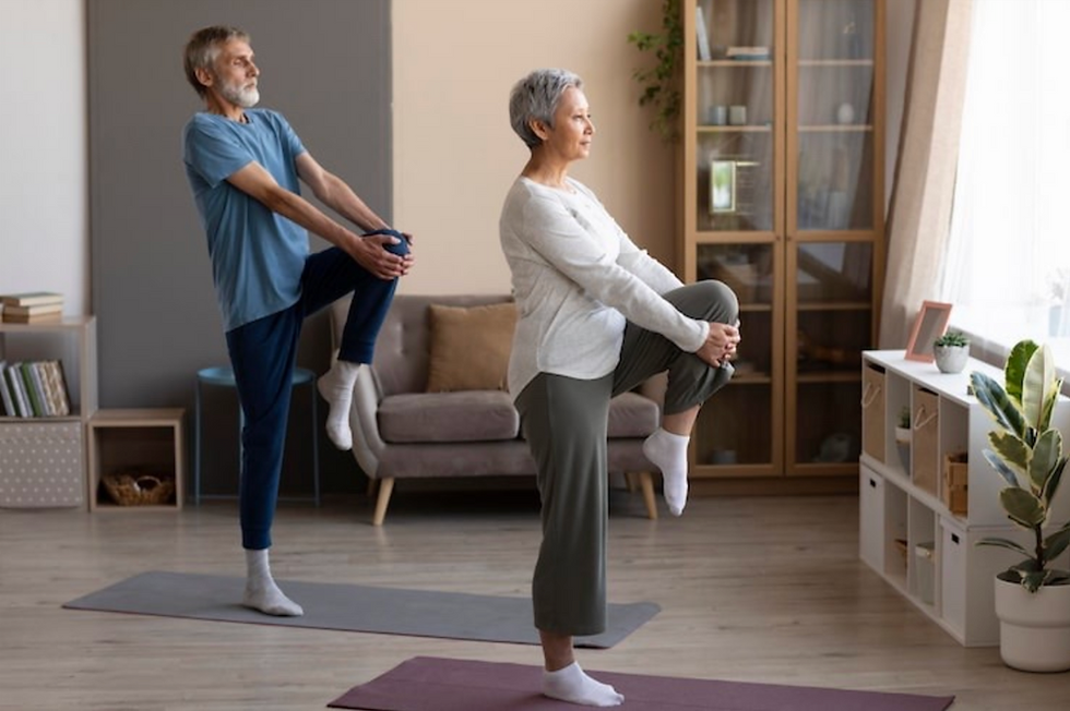 Senior couple performing stability exercises on mats, strengthening posture, focus, and confidence through balance training.