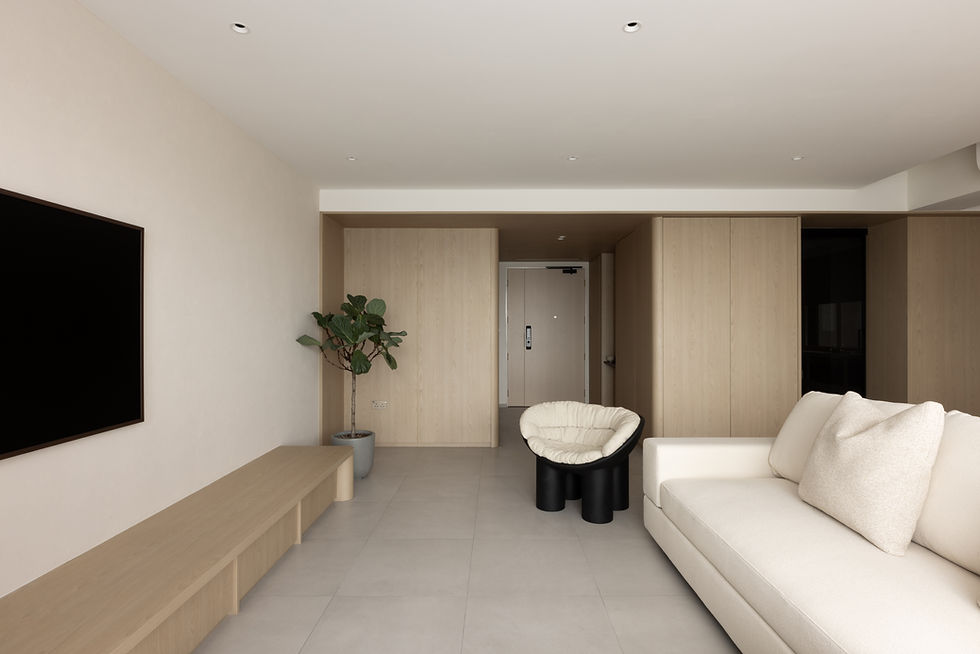 Introspective Apartment – Living room viewed towards the foyer, with light timber wall panels framing the transition into the apartment.