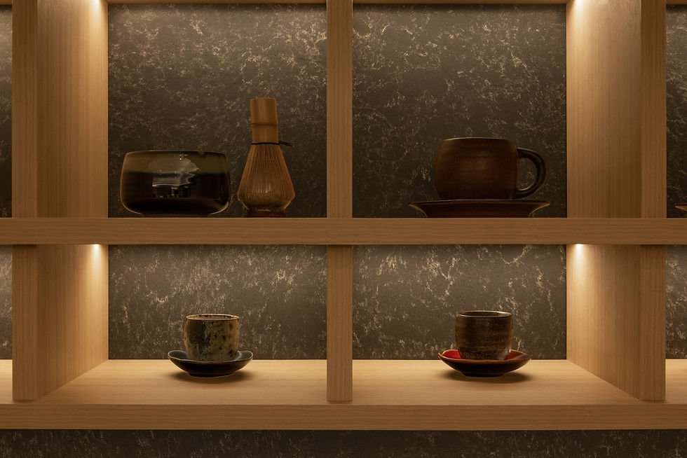 NAMA illuminated display shelving showcasing ceramics and collected objects against a textured stone backdrop.