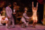 Carla with her arms raised in a gold, Gatsby dress. She is surrounded by three men in suits.  
