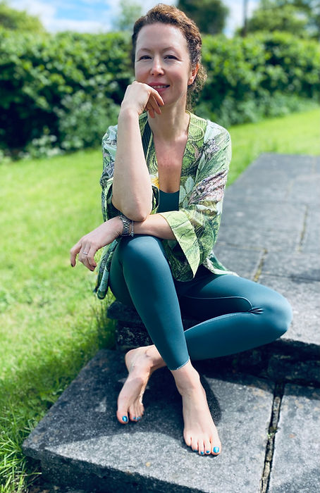 Polina of Radiant years smiles at the camera seated in green outfit