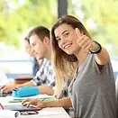 happy-student-thumbs-up-classroom-looking-you-classmates-background-96531919.webp