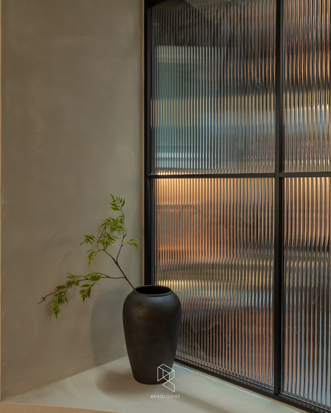 Curved office dining nook beside a luxury black pantry with fluted-glass doors.