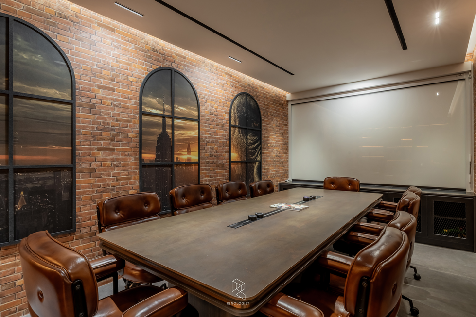 Industrial-style meeting room with brick walls, leather chairs and illuminated display shelving.
